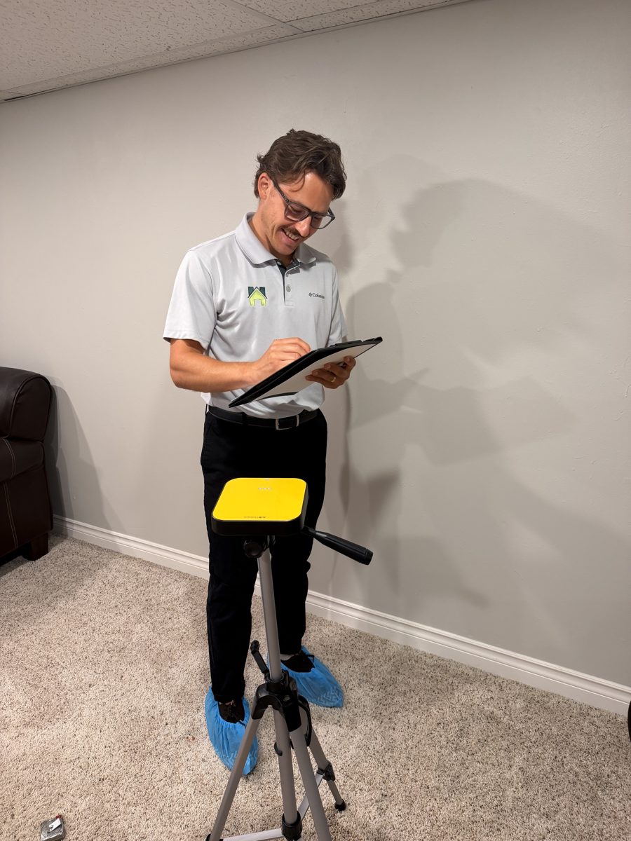 Certified radon measurement specialist logging readings on a tablet